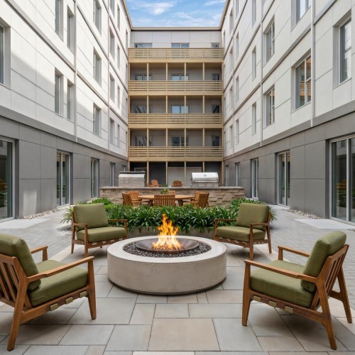 a courtyard with chairs and a fire pit