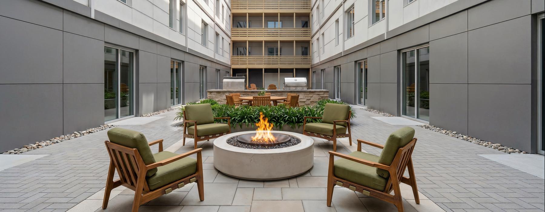 a courtyard with chairs and a fire pit
