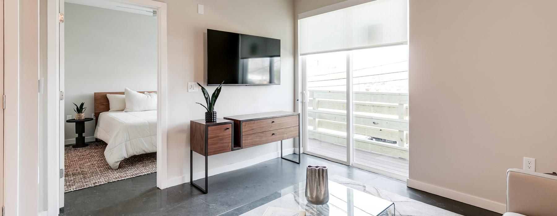 a living room with a glass coffee table and a large window